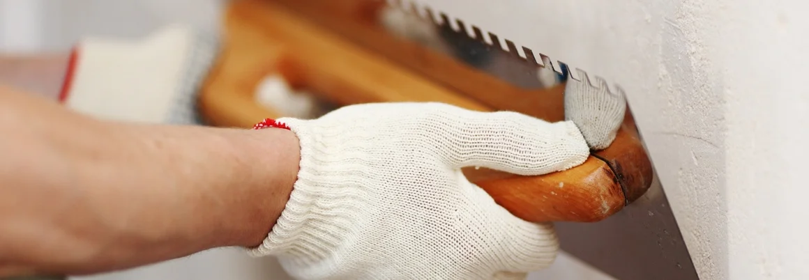 Person verputzt Wand mit Kelle